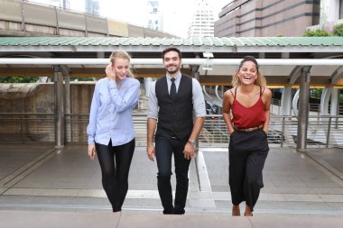 Mutlu gülümseyen Kafkasyalı genç işadamı ve iş kadını gayri resmi giyimi, öğle arasında şehir manzarası arka planında yürürken tartışıyorlar ve proje hakkında tartışıyorlar.