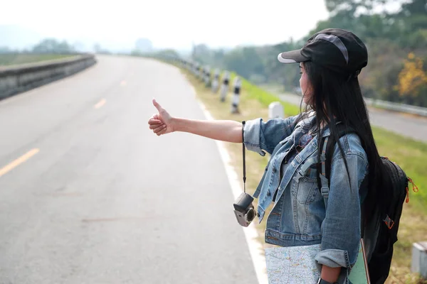 Jovem asiático viajante com mochila esperando carro na estrada enquanto viaja durante as férias — Fotografia de Stock