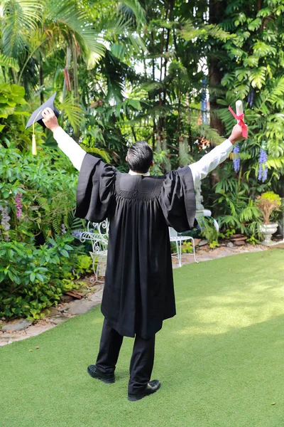 Feliz hombre graduado sosteniendo y mostrando grado, idea para educati — Foto de Stock