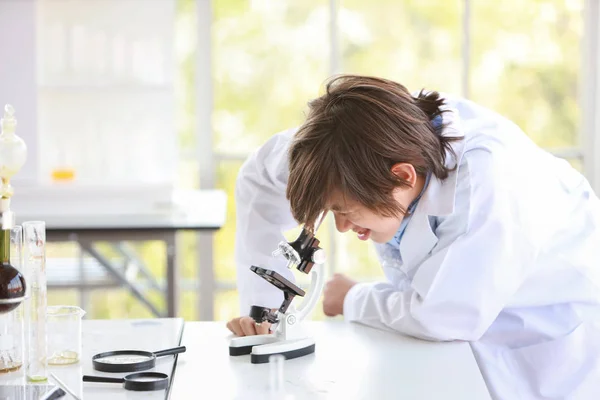 Szczęśliwy mały chłopiec podejmowania eksperymentów naukowych z mikroskopem (edukacja i koncepcja naukowca) — Zdjęcie stockowe