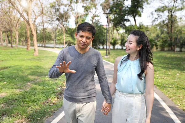 亚洲夫妇走，在公园里说话与幸福的脸 — 图库照片