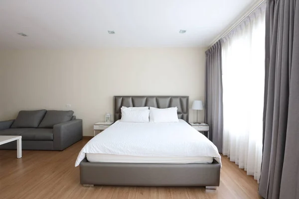 Framsidan av nya moderna pärla och vitt sovrum med vit säng och mjukt klart fönster ljus — Stockfoto