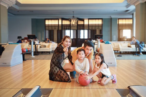 Gruppe des Glücks asiatische Familie Vater, Mutter, Sohn und Tochter spielen Bowling im Sportverein mit glücklich lächelndem Gesicht während der Ferien — Stockfoto