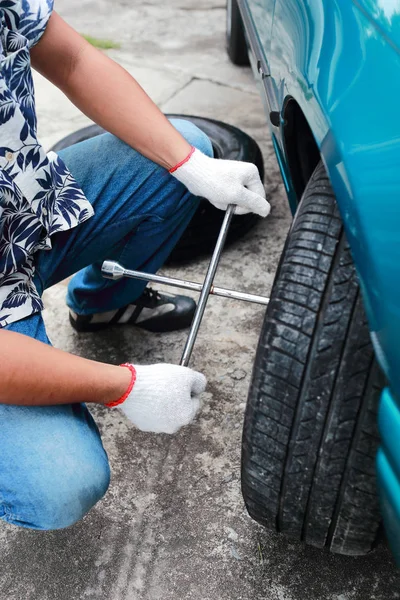 Mãos mecânicas trocam um pneu de carro na rua — Fotografia de Stock