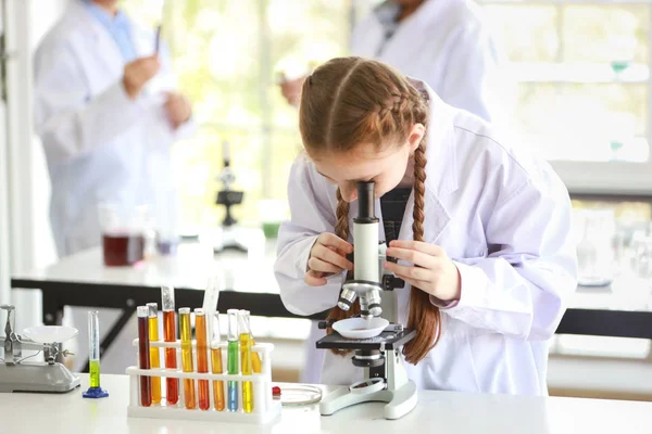Feliz niña caucásica haciendo experimentos científicos con microscopio (educación y concepto científico ) — Foto de Stock