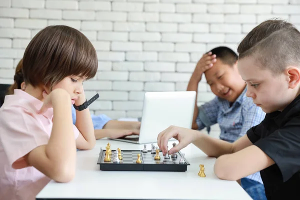Niños lindos e inteligentes jugando ajedrez en clase —  Fotos de Stock