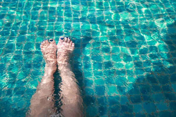Gambe donna in piscina in vacanza — Foto Stock
