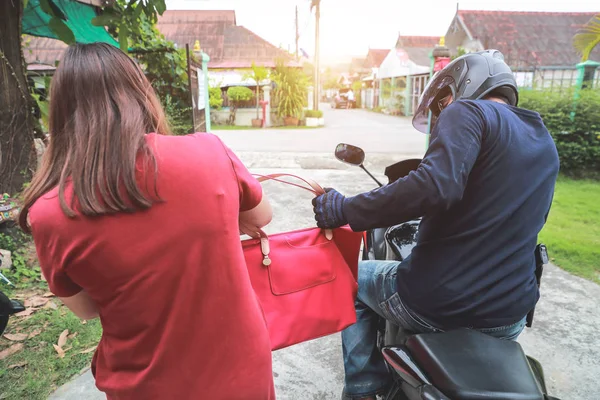 sokakta habersiz kadından çanta veya para çalmaya çalışırken silah ile motosiklet üzerinde hırsız (hırsızlık kavramı)