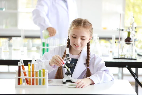 Περίεργο κορίτσι παιδί πειραματίζεται επιστήμη με μικροσκόπιο και το πρόσωπο προσοχή (εκπαίδευση και επιστήμη έννοια) — Φωτογραφία Αρχείου