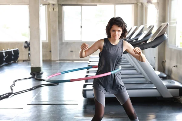 Boa forma de mulher caucasiana no esporte desgaste exercitando-se no aro hula no ginásio ou fitness — Fotografia de Stock