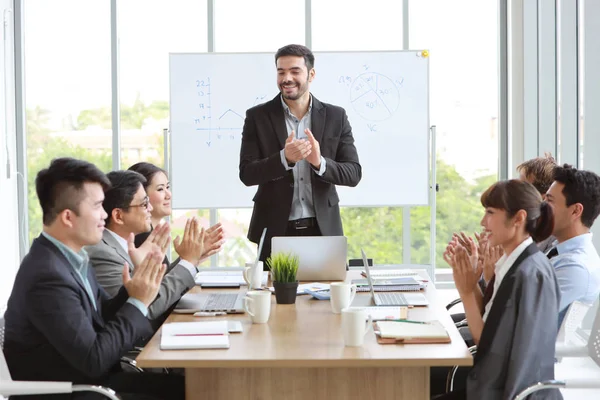 Kaukasiska föreläsare ger offentlig presentation i mötesrum och multietniska affärsmän är uppmärksamma (utbildning eller seminarium koncept) — Stockfoto