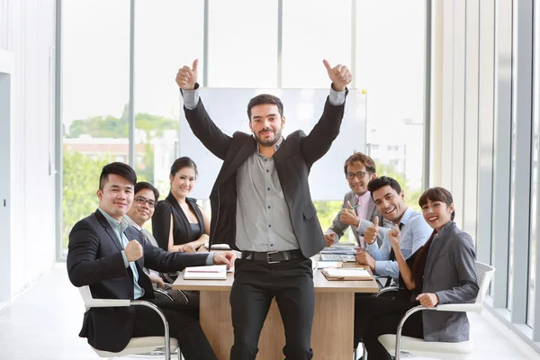 Multietniskt affärsfolk diskuterar företagets vinst eller projektresultat i mötesrum då de visar tummen upp mening med sitt jobb är framgång med leende och glada ansikten — Stockfoto