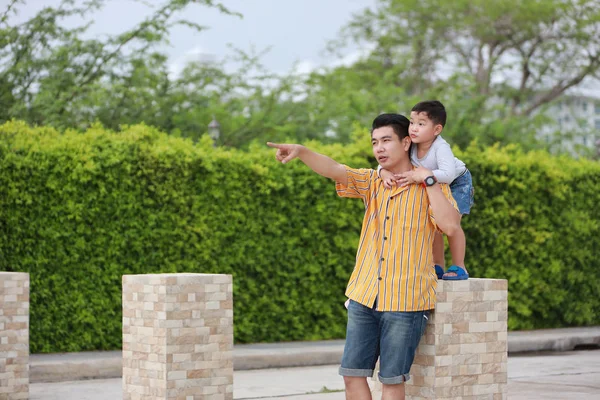 happy asian young single dad holding his son hand with happy smi