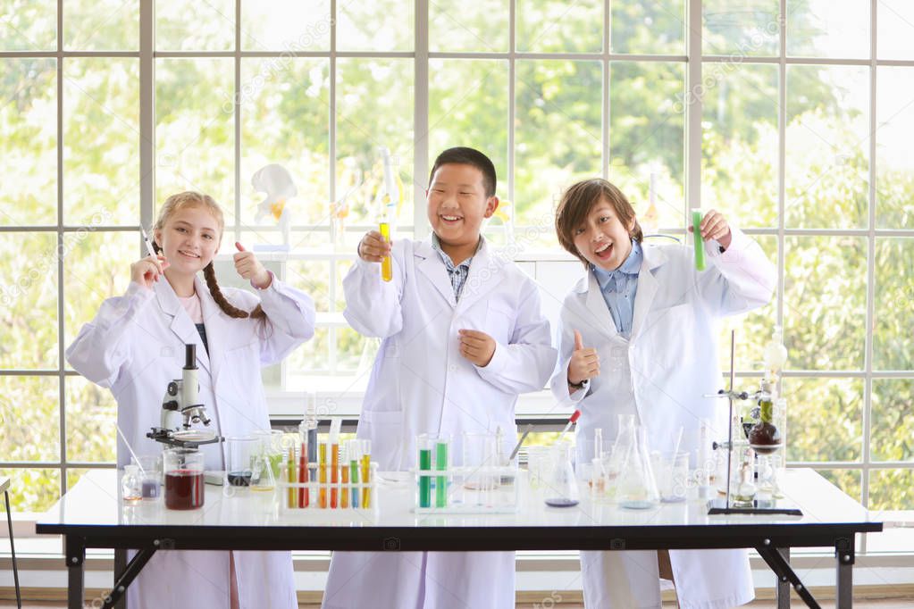 happy kids making science experiments with smiling face. (education and scientist concept)