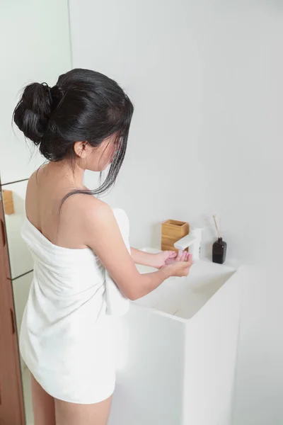 リアビュー健康なアジア人女性ですバスルームで手を洗うタオル — ストック写真