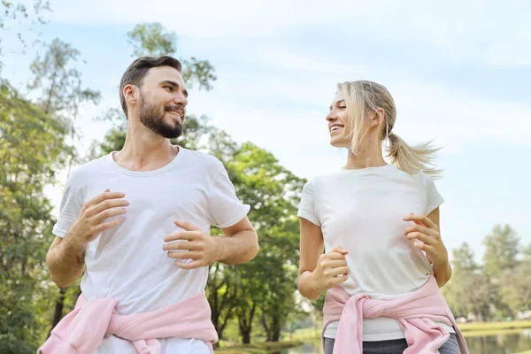 在夏季，年轻夫妇和健康的高加索人喜欢在公园里慢跑（健康的或情人节的观念）) — 图库照片