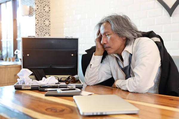 Gescheiterter Geschäftsmann im schwarzen Anzug, der auf Holztisch schläft, mit Alkoholflasche, Computer und Handy auf Holztisch (Konkurs oder arbeitsloses Konzept)) — Stockfoto