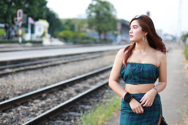 Portrait de jeune femme asiatique en robe verte avec soleil glassess regarder loin dans la gare avec le visage de beauté — Photo