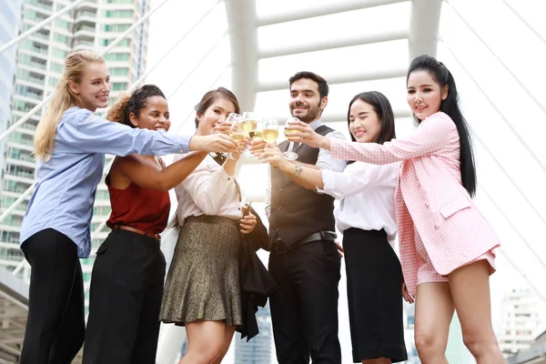 Gente de negocios multiétnicos exitosos son tintinear copas de champán con sonreír mientras se celebra al aire libre — Foto de Stock