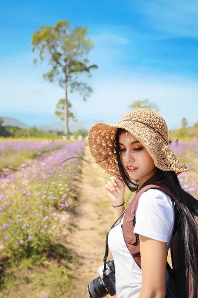 亚洲美女 白衬衫长发 头戴照相机 头戴礼帽 天色蔚蓝 华丽可爱的女孩在鲜花农场里尽情享受 野外旅行的概念 — 图库照片