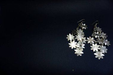 siyah arka planda çiçek şeklinde kulak halkası