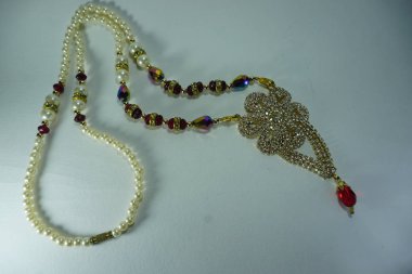 beyaz arka planda taş ve inci ile renkli bir kolye