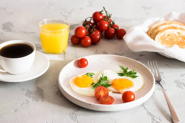Uova fritte con pomodori ed erbe aromatiche, pane tostato, caffè e succo di frutta — Foto Stock