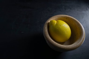 Iemon izole ahşap kasede koyu arkaplanda fotokopi alanı solda.