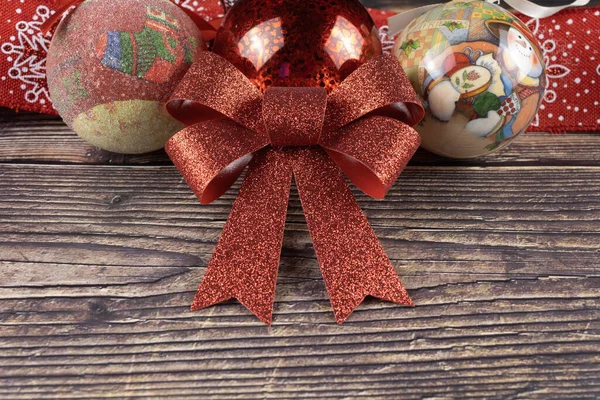 christmas balls and red ribbon on a wooden background. with free space for text at the bottom