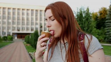 Redhead kız yiyor ve lezzetli dondurma tadını çıkarın