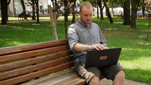 Kerl Park Arbeitet Einem Laptop Einem Sonnigen Tag — Stockvideo