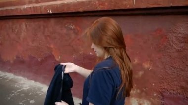 Kızıl saçlı kız sokakta yürüyor