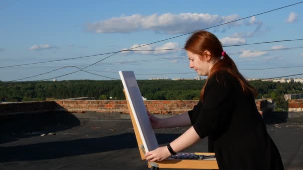 Red Haired Girl Paints Picture Roof House Sunny Day — Stock Video