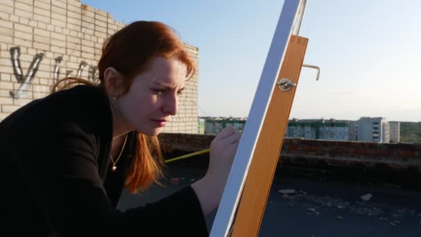 Red Haired Girl Paints Picture Roof House Sunny Day — Stock Video