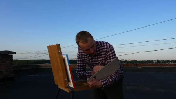 Guy Paints Picture Roof House Sunset — Stock Video