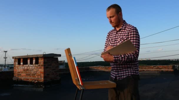 Guy Paints Picture Roof House Sunset — Stock Video