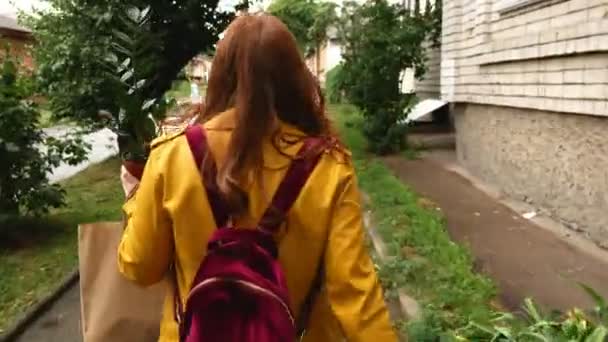 Una Chica Camina Por Ciudad Con Una Planta Tiempo Nublado — Vídeos de Stock