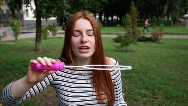 Ragazza Dai Capelli Rossi Soffia Bolle Sapone Nel Parco Lei — Video Stock