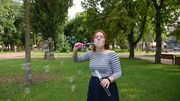 Roodharige Meisje Blaast Zeepbellen Het Park Glimlachend Lachen Zomer Geluk — Stockvideo