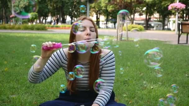 Roodharige Meisje Blaast Zeepbellen Het Park Glimlachend Lachen Zomer Geluk — Stockvideo