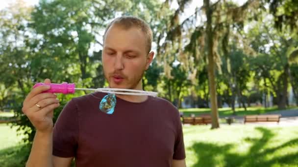 Tipo Con Barba Sopla Burbujas Jabón Parque Día Soleado — Vídeo de stock