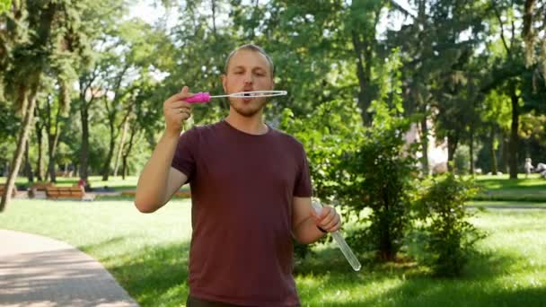 Killen Med Skägg Blåser Såpbubblor Parken Solig Dag — Stockvideo