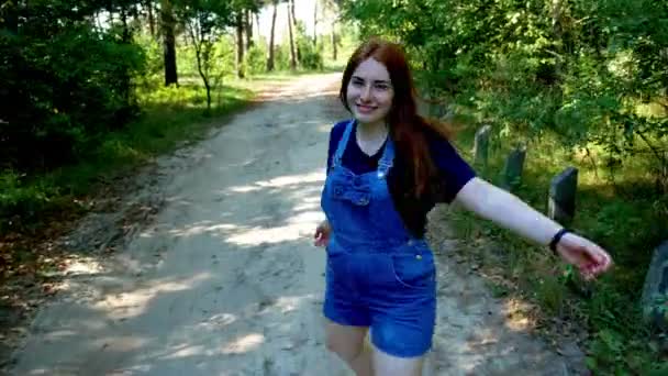 穿蓝色工作服的女孩穿过夏天的森林 — 图库视频影像