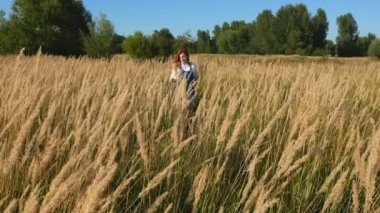 sivri bir alanda mavi tulum kırmızı saçlı kız