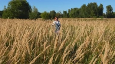 sivri bir alanda mavi tulum kırmızı saçlı kız