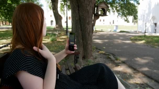 Chica Utiliza Teléfono Inteligente Parque Banco Madera — Vídeo de stock