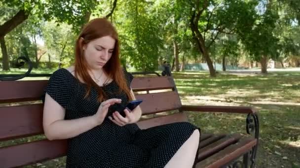 Ragazza Utilizza Suo Smartphone Nel Parco Una Panchina Legno — Video Stock