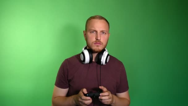 Konzentrierter Mann Mit Abmontierten Kopfhörern Spielt Konsole — Stockvideo