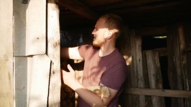 一个男人在村子里用手拿柴火 — 图库视频影像