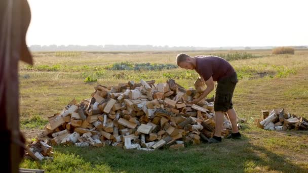 Een Man Draagt Brandhout Met Zijn Handen Het Dorp — Stockvideo